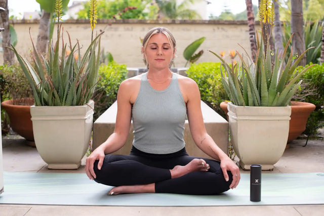 Woman in a peaceful yoga pose, demonstrating stress-relief techniques for preventing PMS