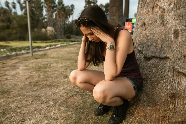 a woman crouching on the roadside due to hormonal imbalance and anxiety
