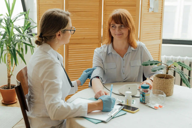 Doctor checking patient's blood pressure, demonstrating how to prevent high blood pressure through regular monitoring