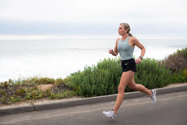  Active woman running by the river, staying aware of signs of choline deficiency that can affect exercise